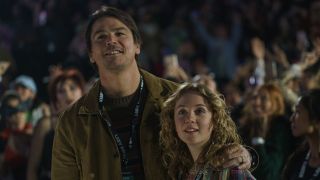 Cooper with his arm around daughter Riley in a concert crowd in M. Night Shyamalan's Trap. 