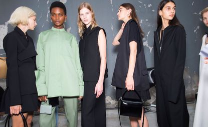 Models wear black dresses and tops and mint top and trousers