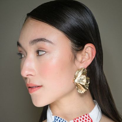 model backstage looking to her right with glowy skin