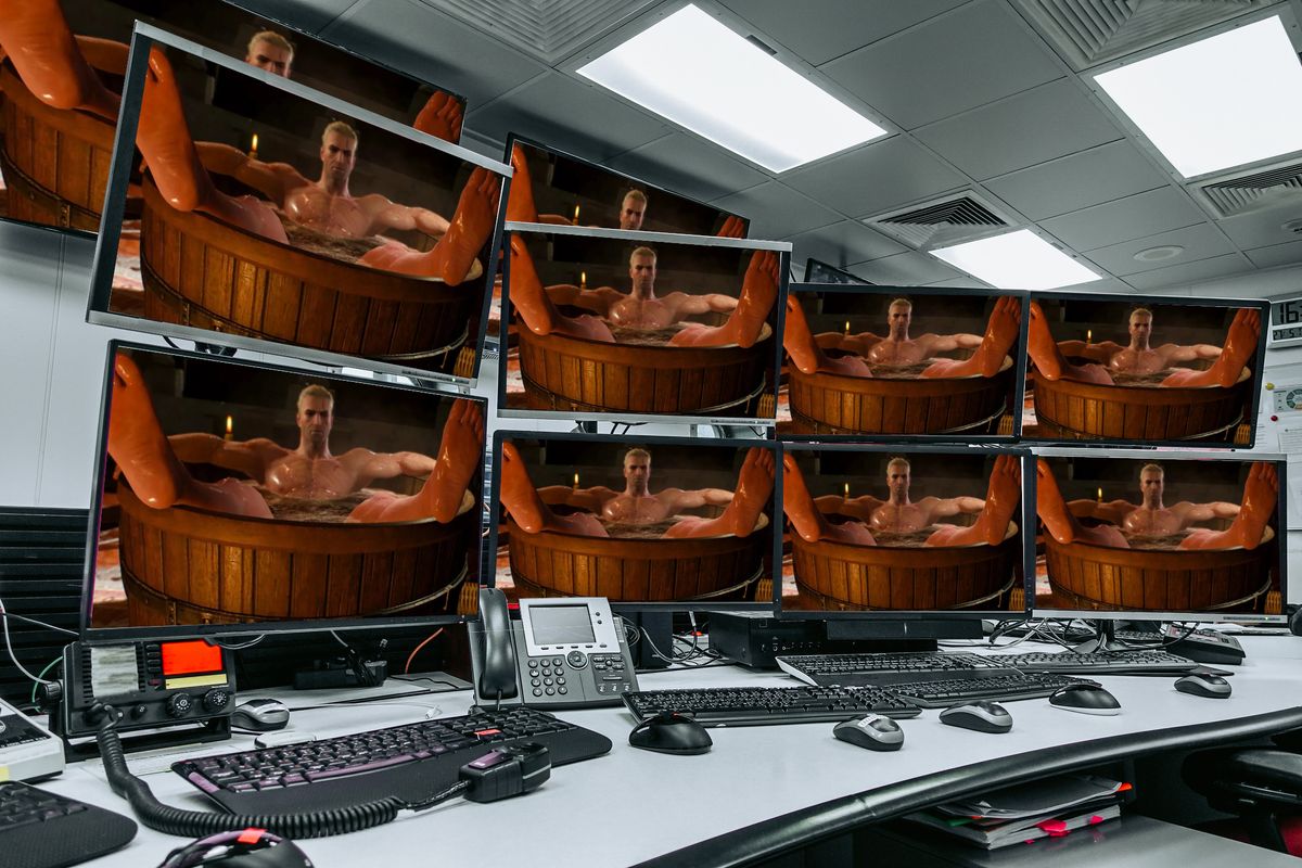 Group of blank monitors and screen on security desk or control room for monitor process or stock data trading photoshopped so each monitor displays Geralt of Rivia soaking in the tub from the beginning of The Witcher 3