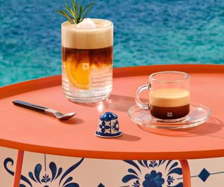 Coffee made in the Nespresso X Pantone on a table top with sea in the background