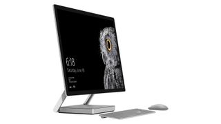 Best all-in-one computer Surface Studio 2 on a table with its keyboard and mouse against a maroon wall
