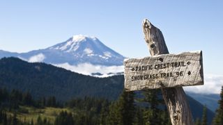 Pacific Crest Trail sign with snowy mountain