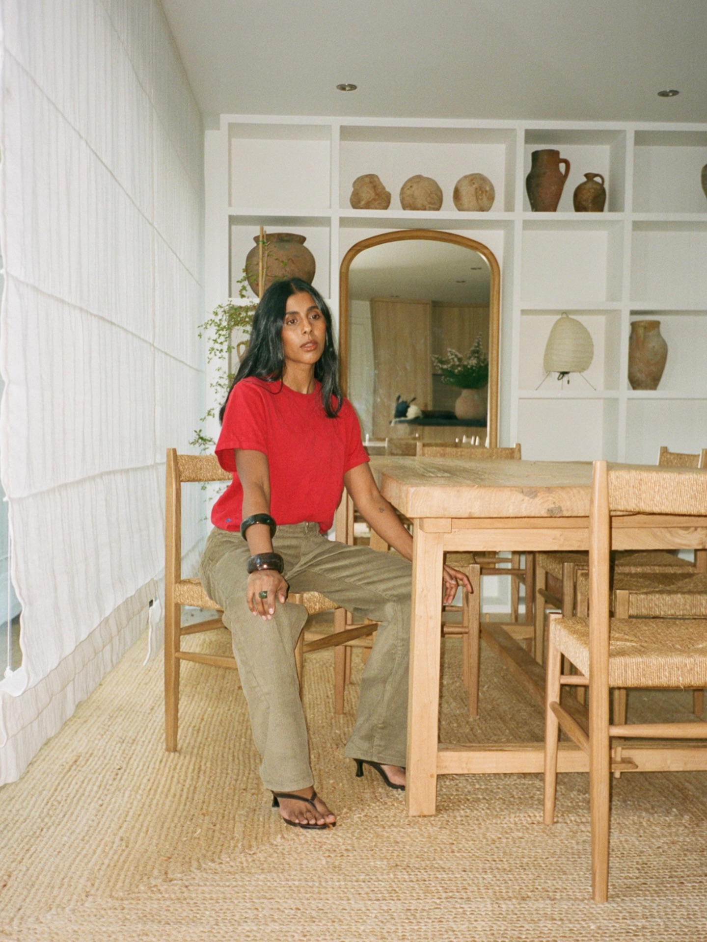 Monikh Dale wears w red t-shirt, khaki trousers and heel flip flops