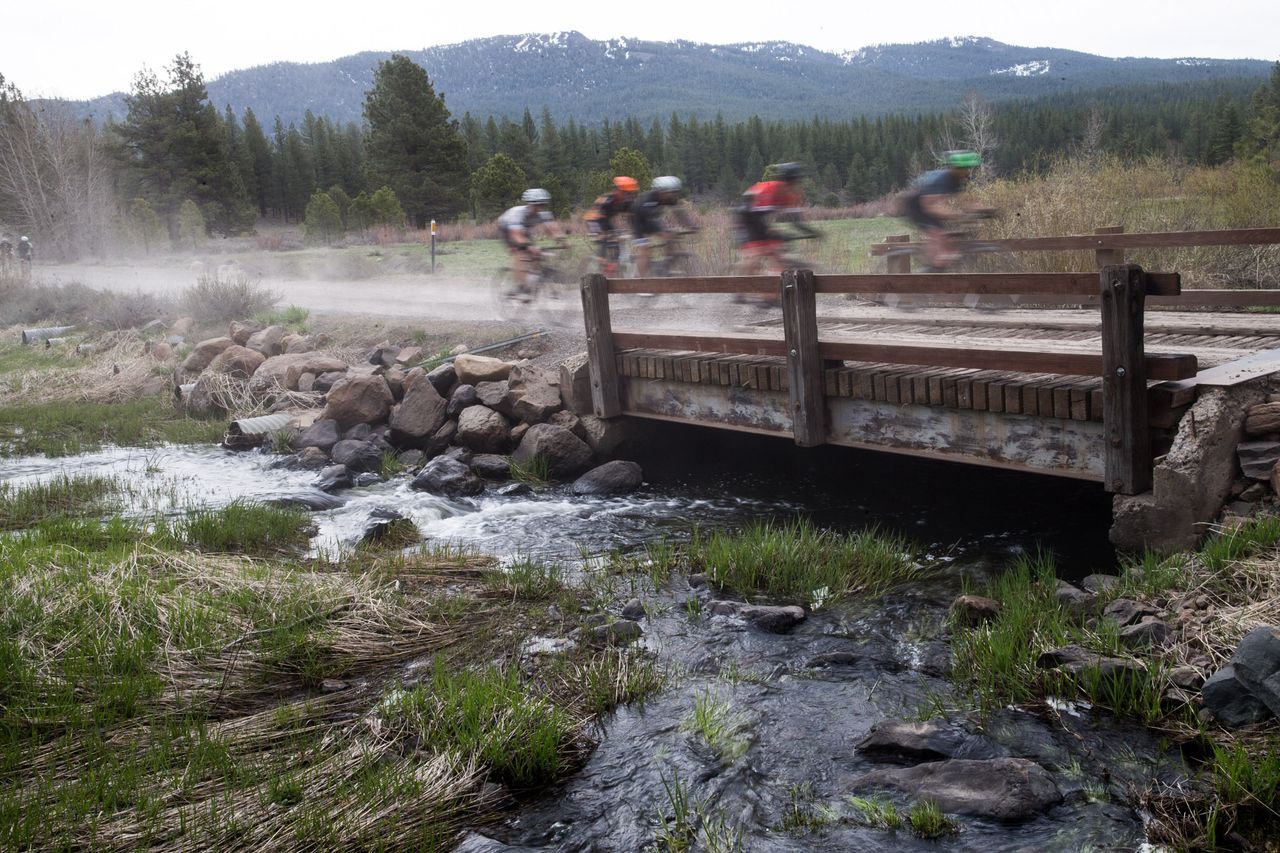 Riders cross a wooden bridge on the dirt roads of the Sagan Fondo on May 5, 2018