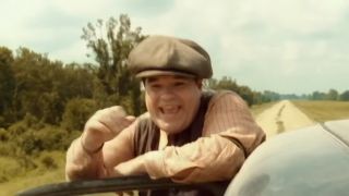 Michael Badalucco smiling while sticking his head out of a car in O Brother Where Art Thou?