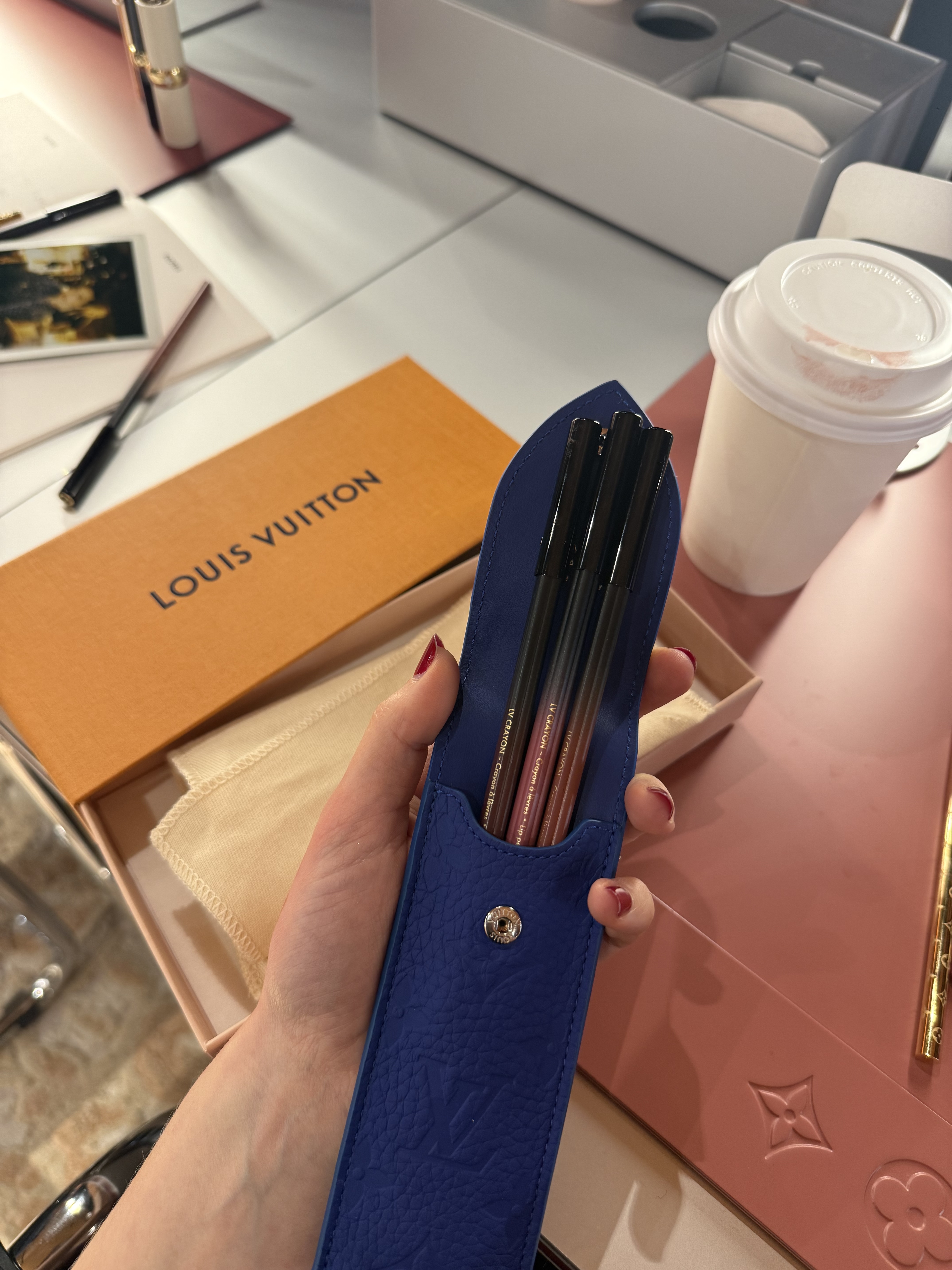 Photo of Jamie Schneider holding the new LV Lip Crayons inside a blue pencil case