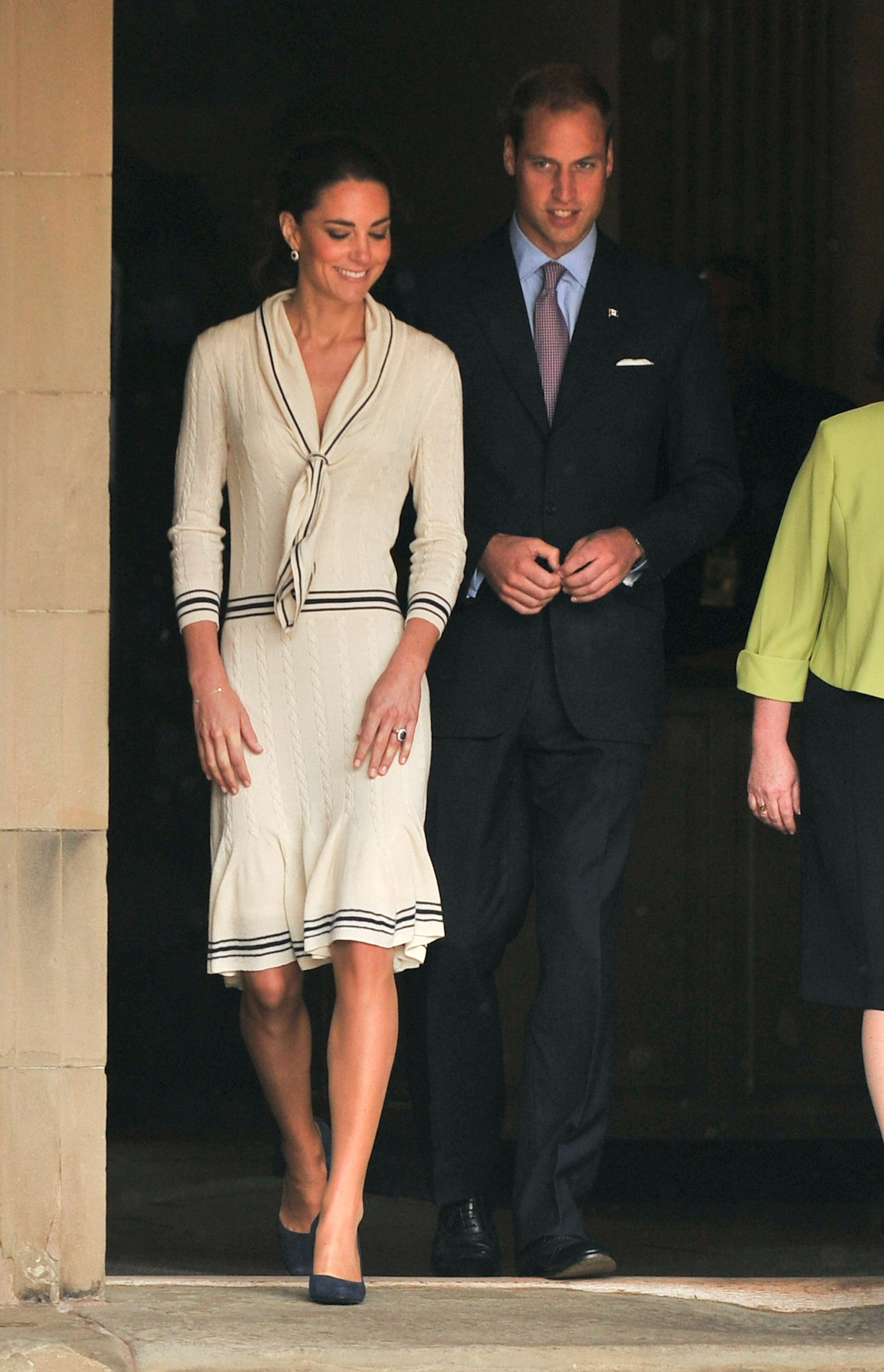 Princess Kate wearing a cream sweater dress walking next to Prince William