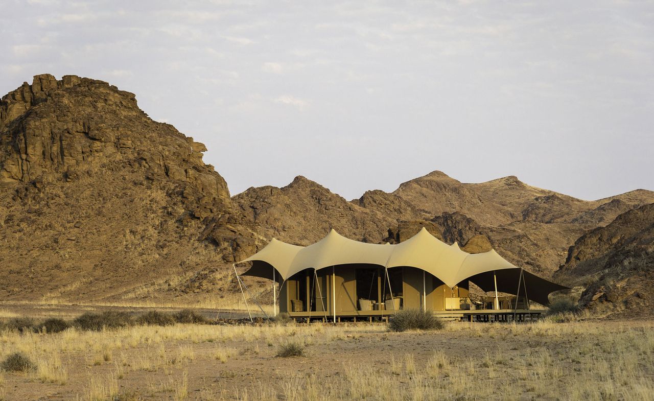 External view of camp in front of rocky mountains