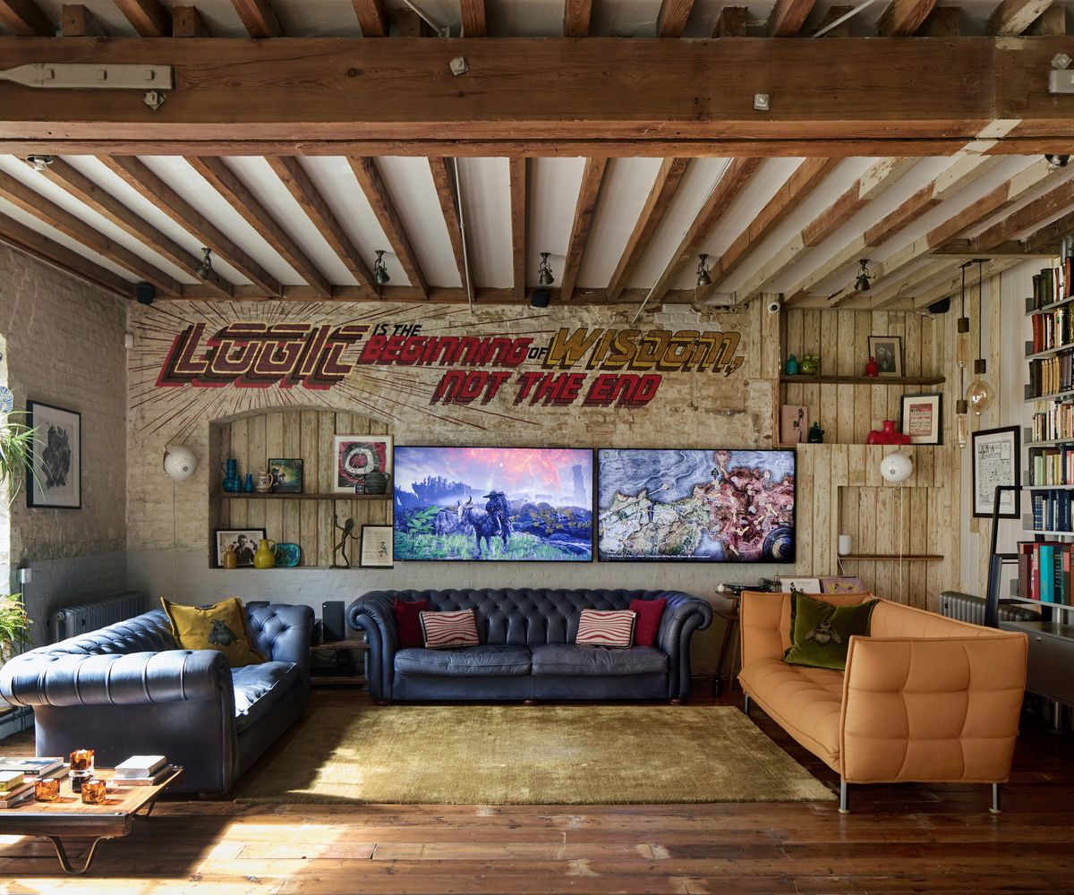 A living room with wooden beamed ceilings and a bookshelf wall