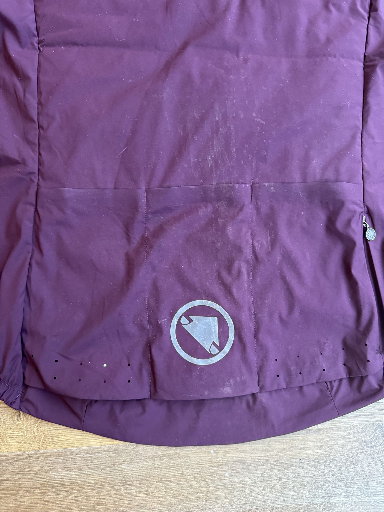 Flay lay Endura jacket in burgundy, pocket detailing showing reflective logo