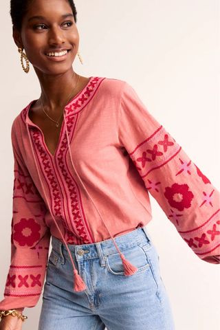 woman wearing pink embroidered shirt