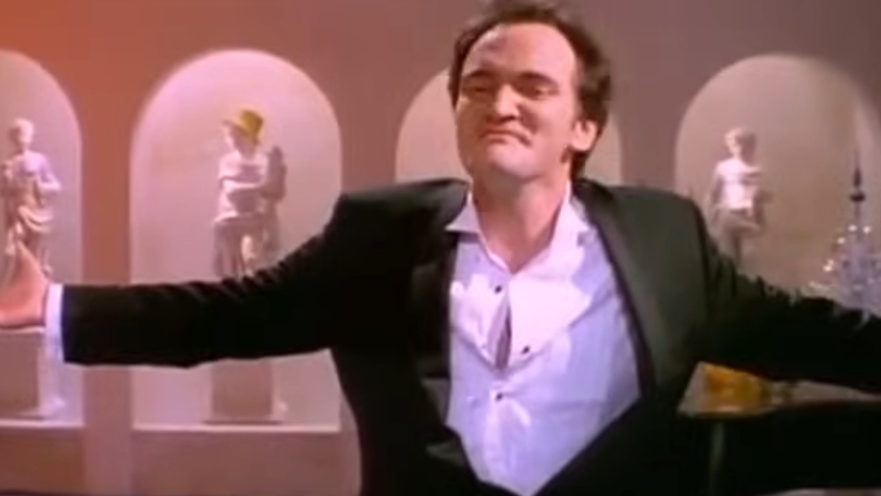 Quentin Tarantino with his arms spread out in Four Rooms