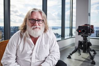 Gabe Newell sitting in an office building