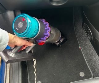 Testing the handheld mode of the Dyson Gen5detect on a car floor mat