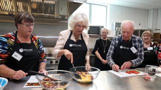 Queen Camilla takes part in a cooking class with the "The Cooks" senior chefs as she attends an Active Elderly engagement at the Salvation Army Centre on November 22, 2019 in New Zealand