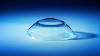 How to put in contact lenses: An image of a clear lens shown on a blue background