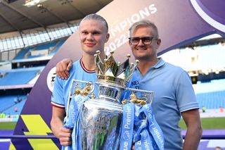 Erling Haaland pictured with father Alf-Inge Haaland and the Premier League trophy at Manchester City in May 2023.