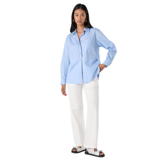 woman wearing light blue shirt and white trousers