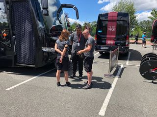 Team Ineos staff check over Chris Froome's helmet