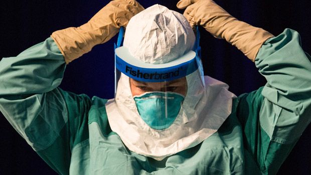 Nurse puts on protective medical gear 