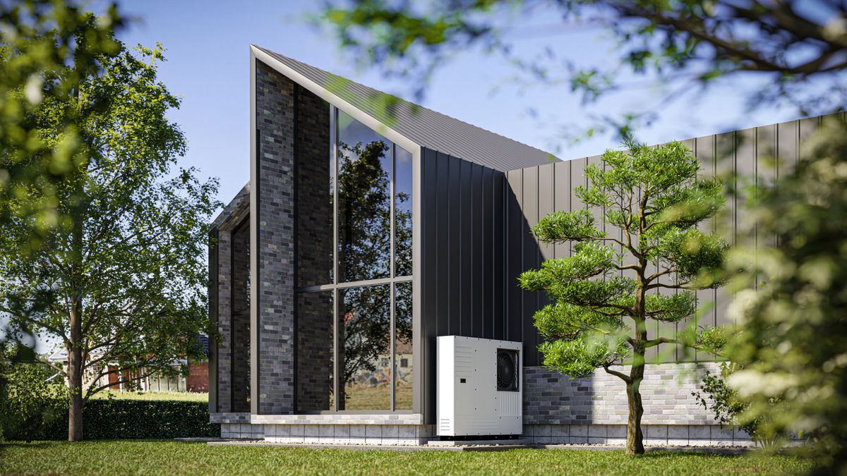 modern grey house with high pitched roof, grey cladding and heat pump attached to side of house