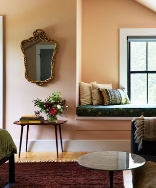 bedroom with peach walls, window bench with teal cushions and sophisticated decor