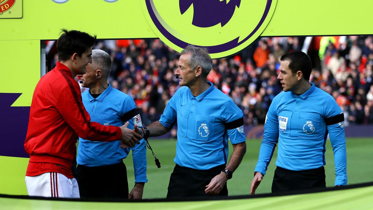 Manchester United captain Harry Maguire shakes hands with referee Martin Atkinson before a Premier League match