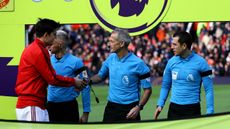 Manchester United captain Harry Maguire shakes hands with referee Martin Atkinson before a Premier League match