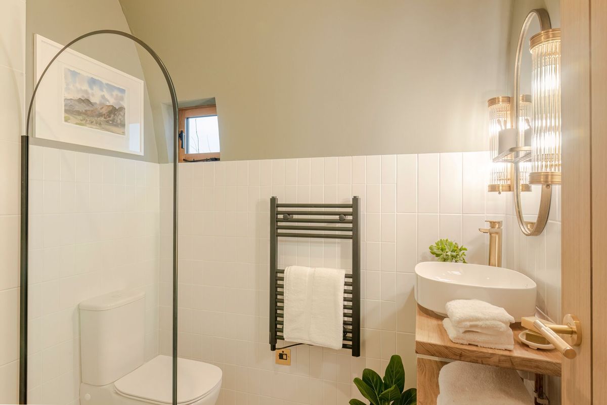 A shower to the left and a black towel rail in the centre