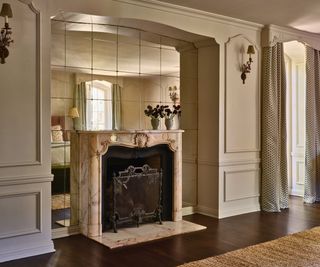 bedroom fireplace with mirrored and marble surround and paneled walls