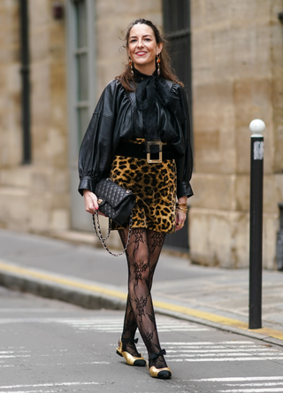 Alba Garavito Torre wears mesh floral print tights and golden flat ballerina Chanel pointy shoes with black tips