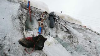 A hiking shoe and other equipment on a glacier