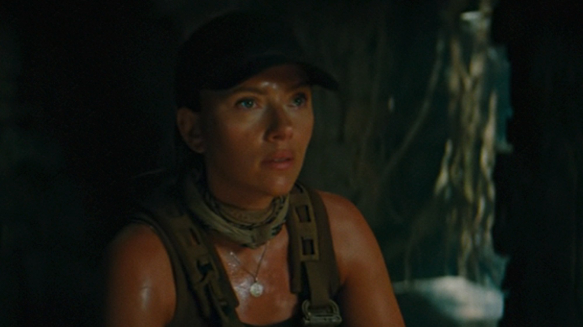 Scarlett Johansson looking very sweaty in a green hat, while in a cave in Jurassic World Rebirth