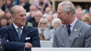 Prince Philip and King Charles listen to speeches together
