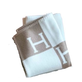 A brown and white checkerboard blanket with Hs on it