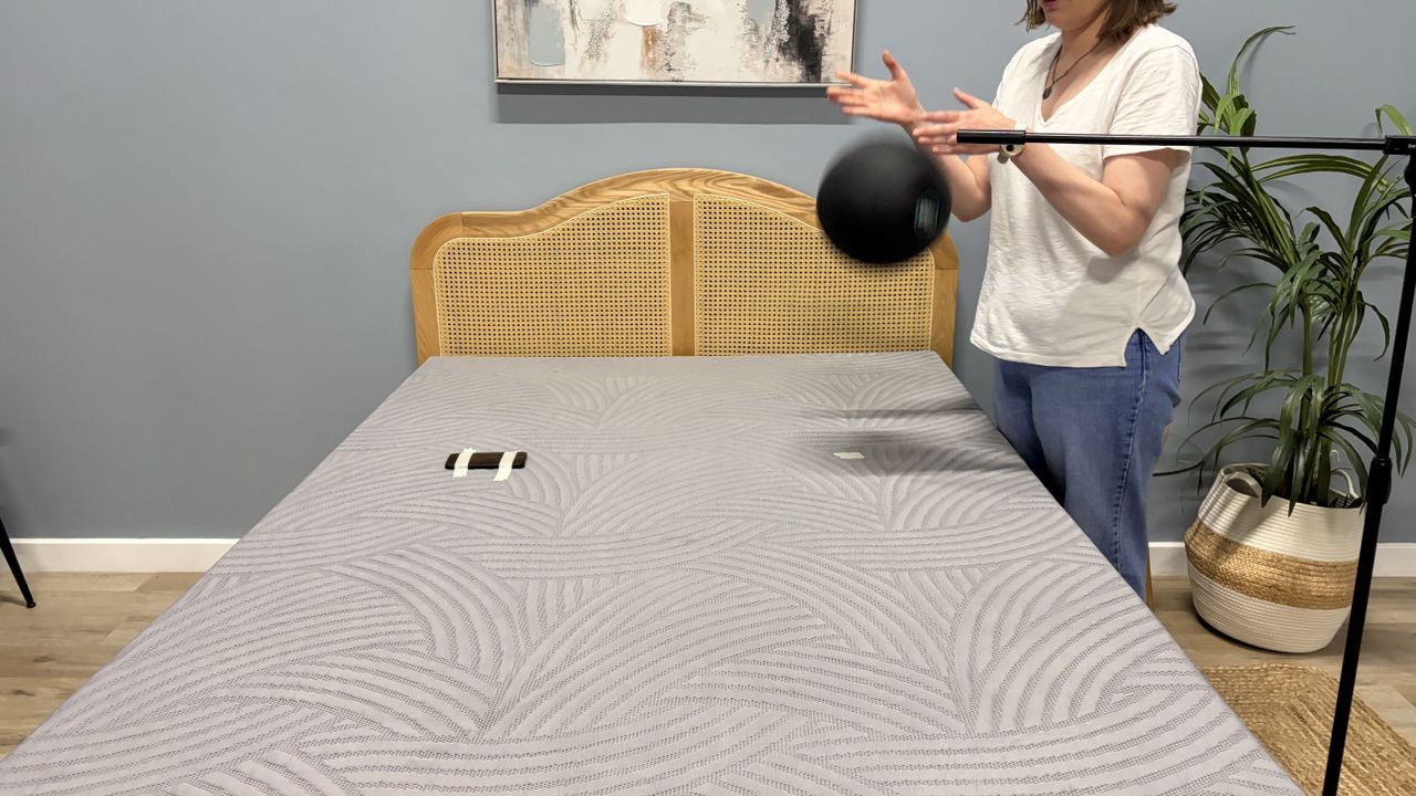 Tester Ruth Jones drops a slam ball on the SweetNight CoolNest mattress to measure the motion isolation.