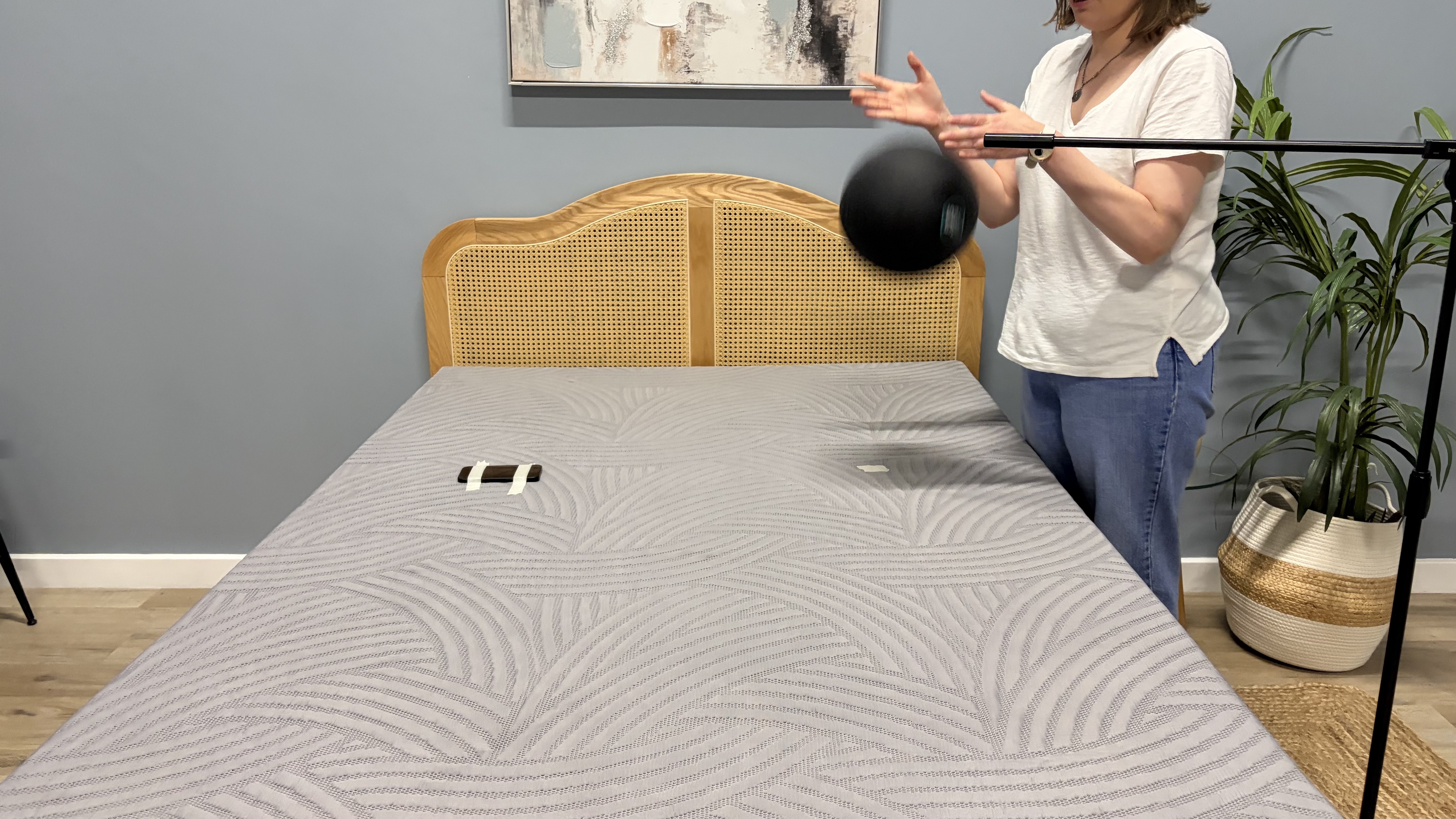 Tester Ruth Jones drops a slam ball on the SweetNight CoolNest mattress to measure the motion isolation.