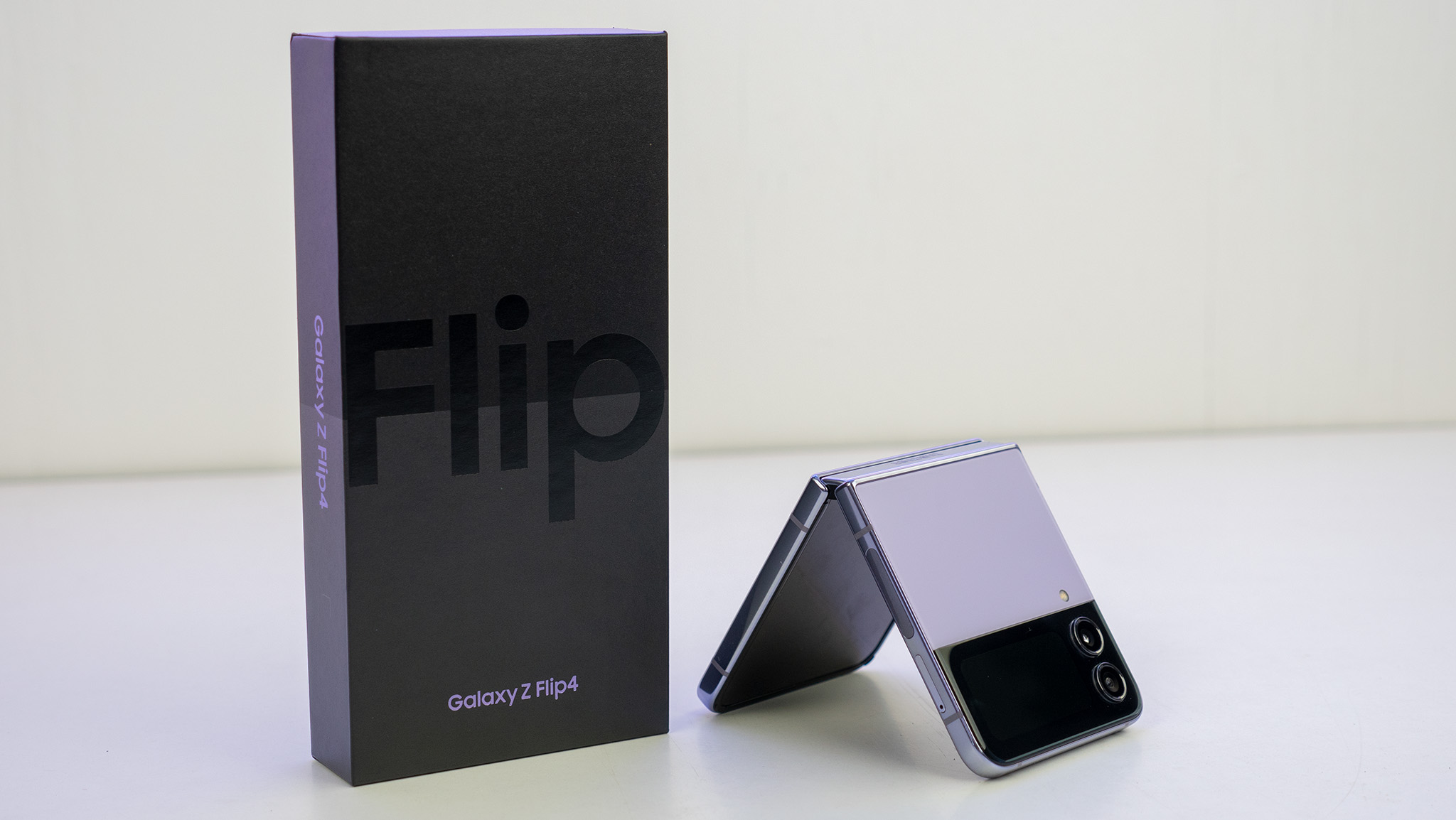 Samsung Galaxy Z Flip 4 in Bora Purple next to the retail box
