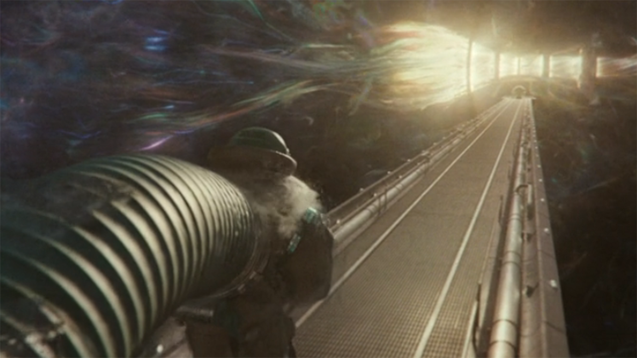 a man in a suit with a huge hose attached to its back walks down a tunnel towards a large ball of light