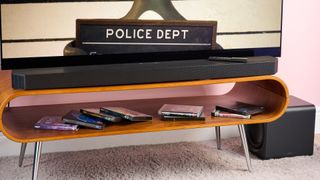 Samsung HW-Q800F with 4K UHD Blu-rays on shelf beneath it