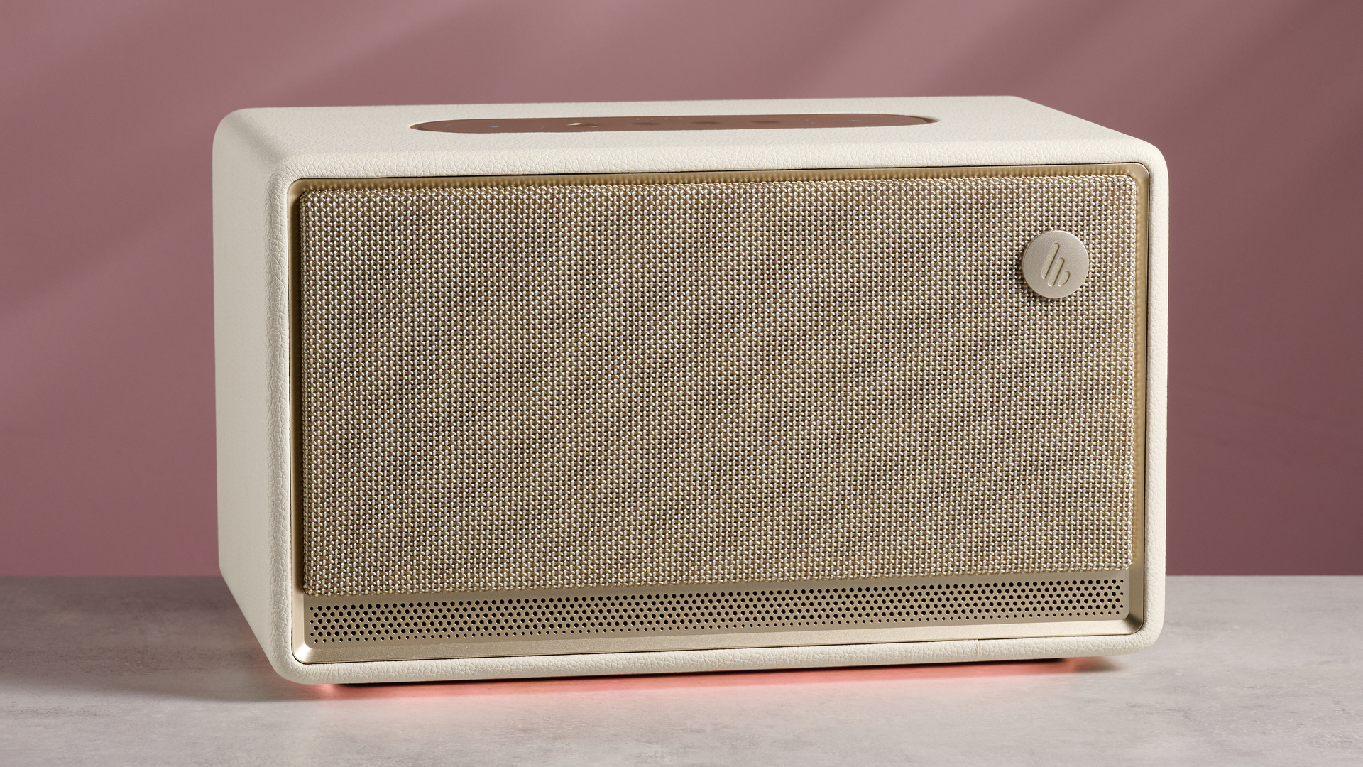 The Edifier ES300 with a glowing amber light beneath, in front of a pink background.