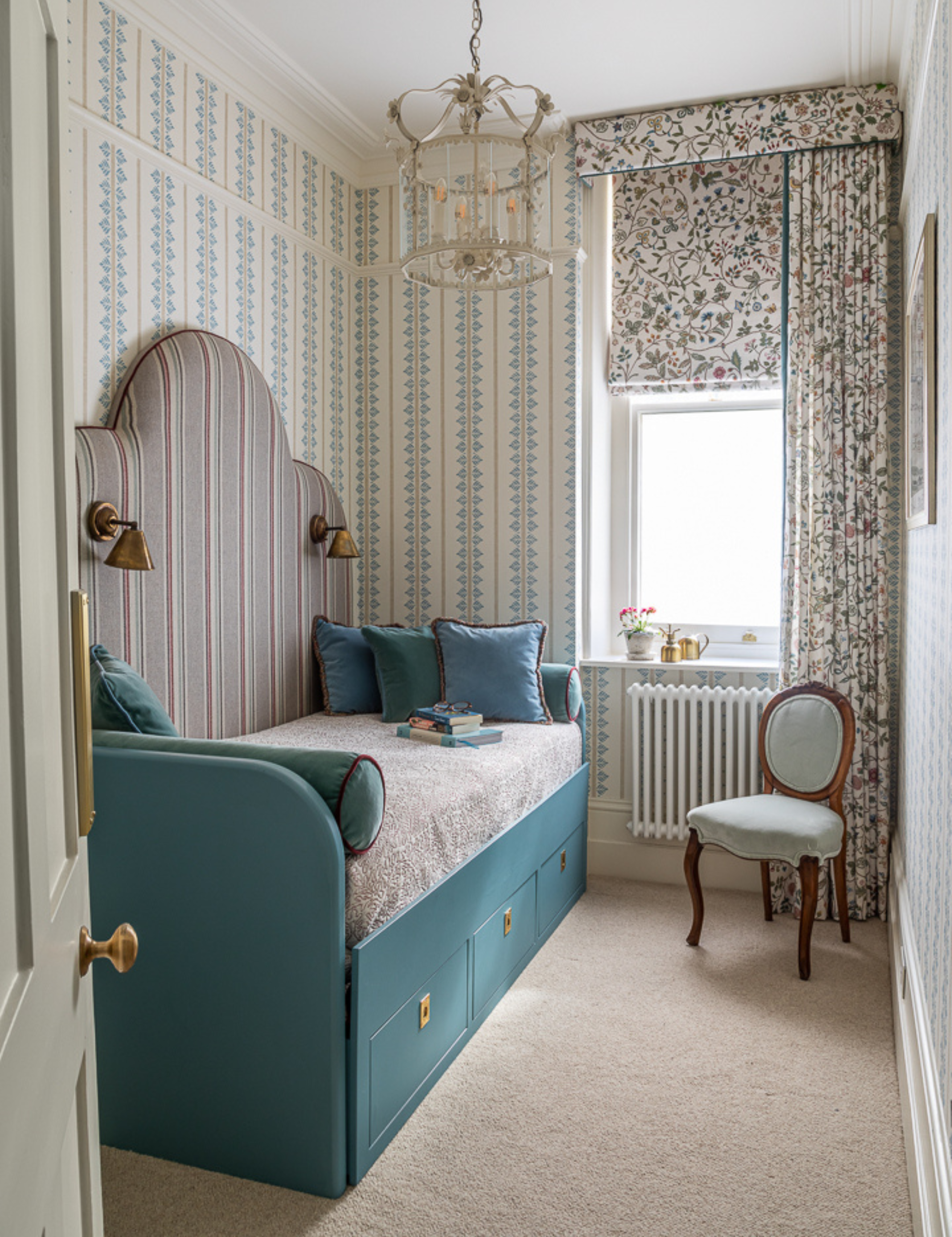 Pattern-drenched, double-dressed window styled inside of an ornately decorated guest bedroom with a teal trundle bed