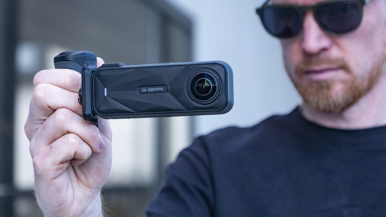 Insta360 X5 Photography Grip attached to the camera, in the hand