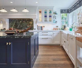 White kitchen with black marble countertop on kitchen island