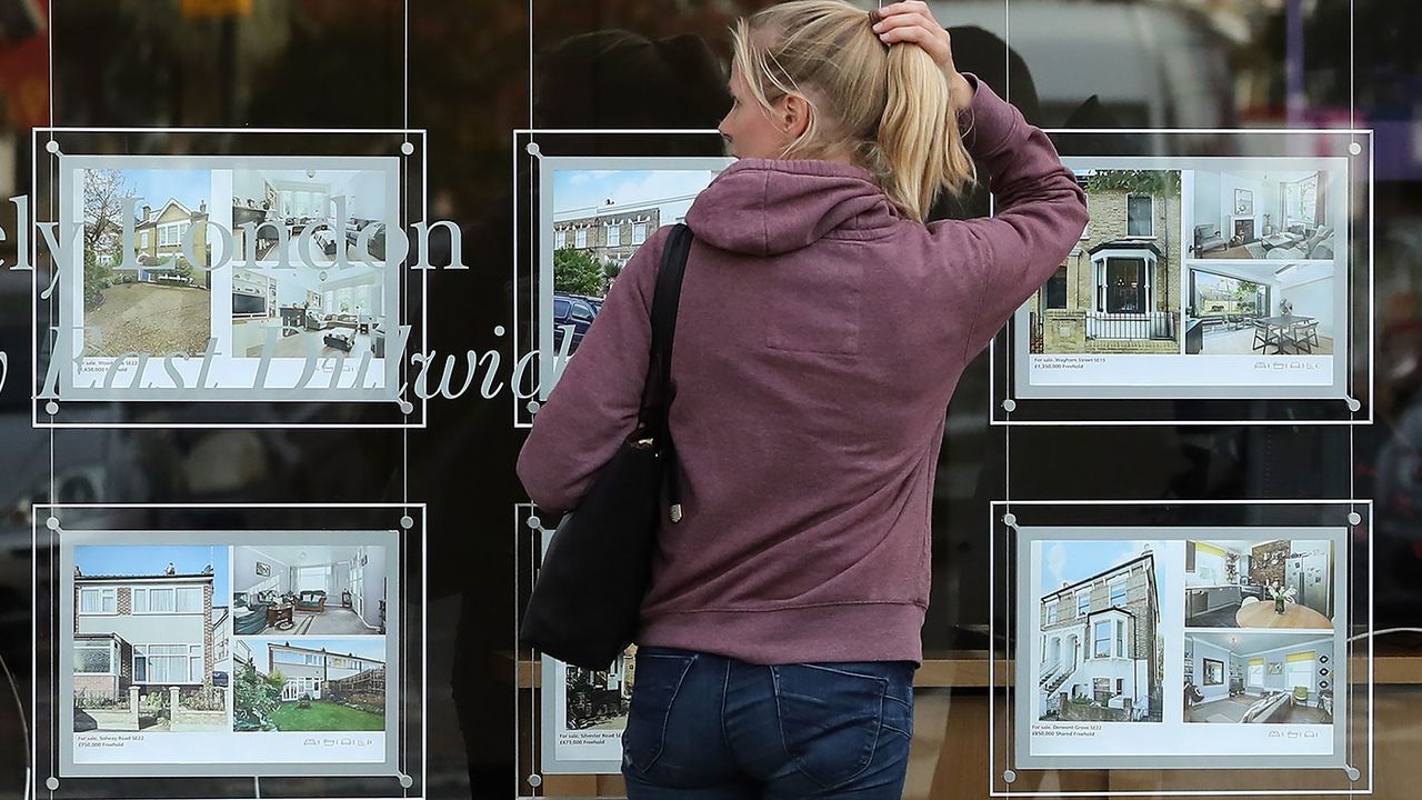 Woman looking in an estate agent&amp;#039;s window