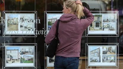 Woman looking in an estate agent's window