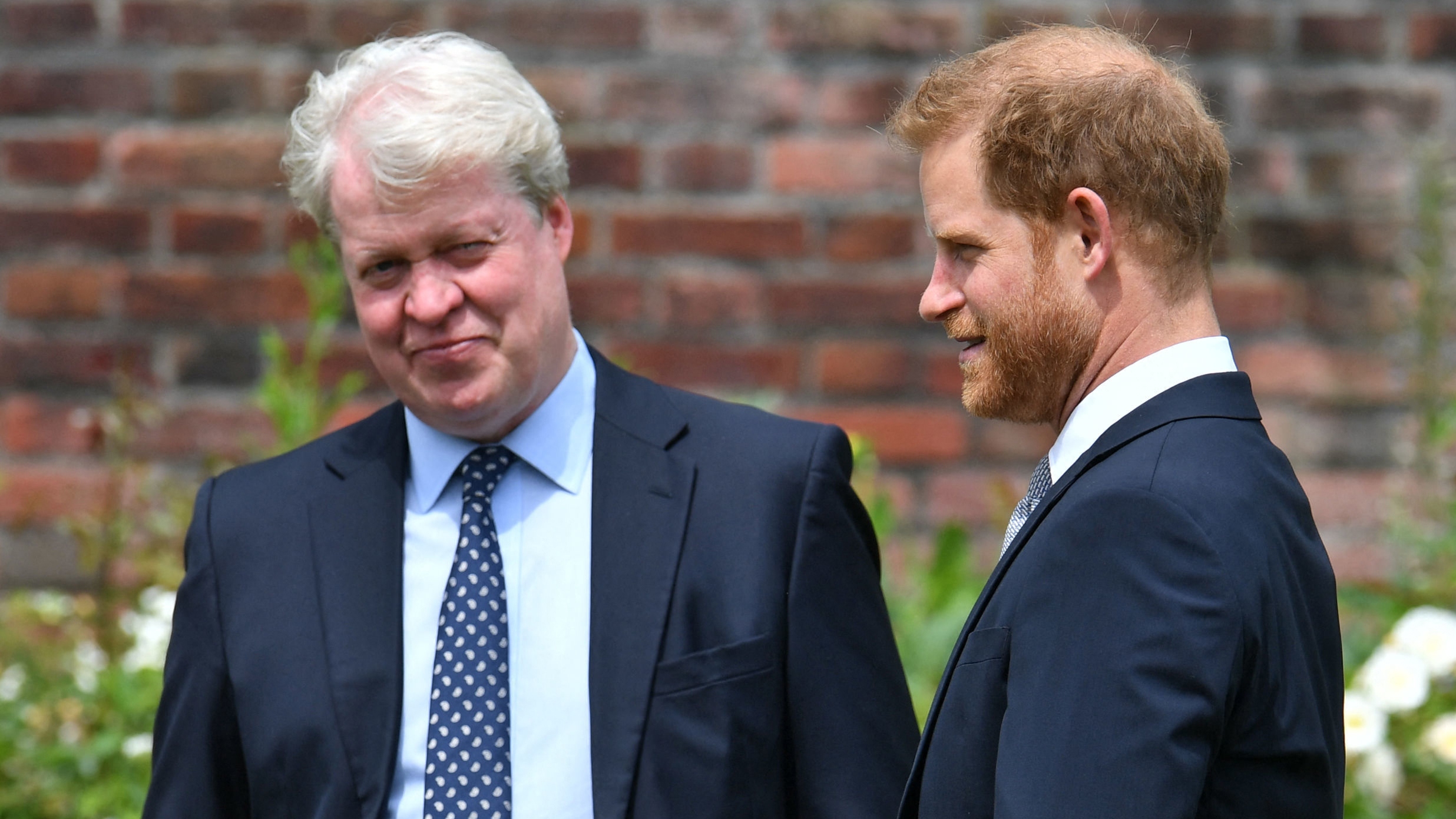 Prince Harry, Duke of Sussex (R) chats with his uncle Earl Spencer ahead of the unveiling of a statue of Princess Diana at The Sunken Garden in Kensington Palace, London on July 1, 2021