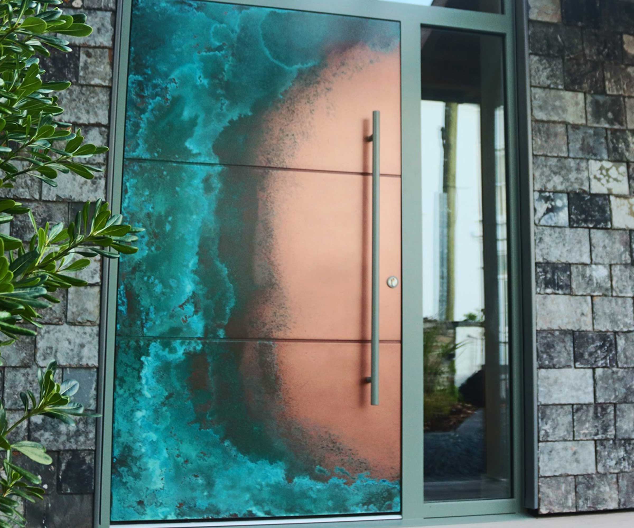 modern home with large copper finish front door and a glazed panel next to the door