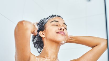 woman shampooing her hair in the shower